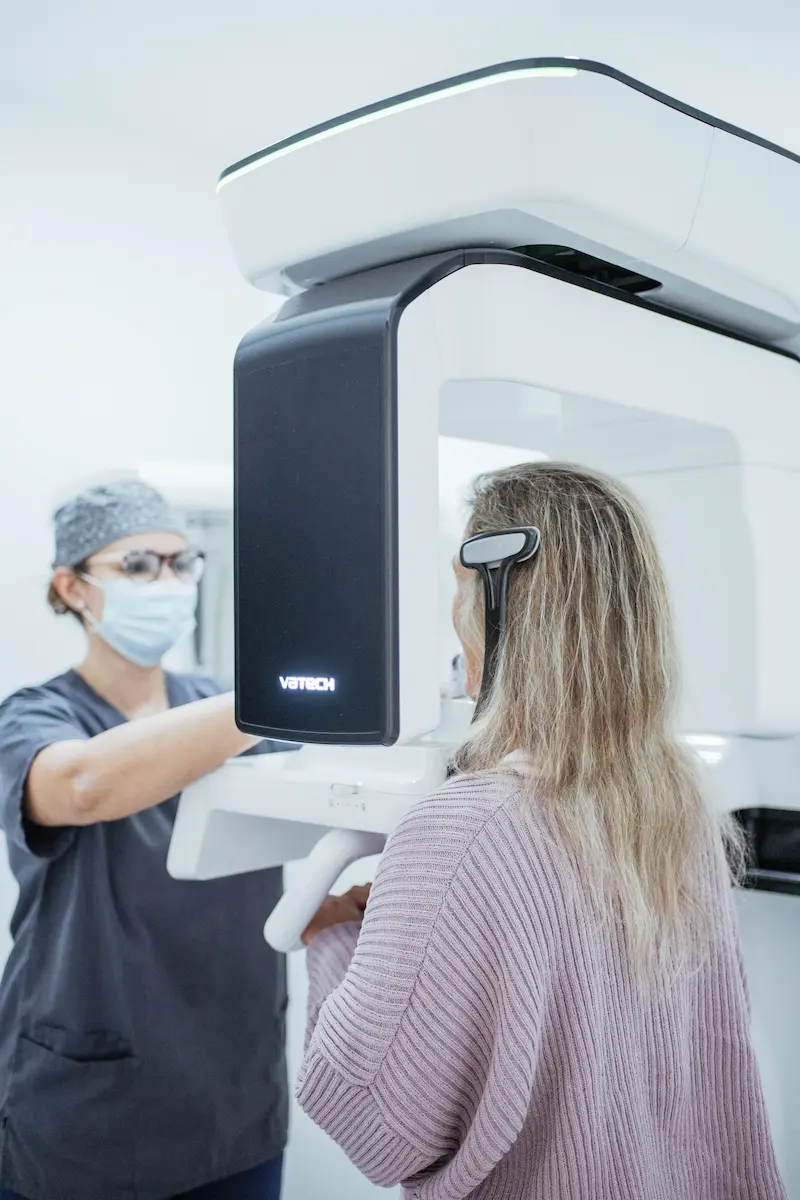 Paciente realiza radiografia na clínica, com equipamento de alta tecnologia para exames.